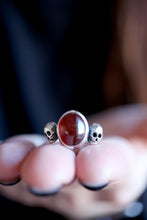 Anell de plata amb Granat i dues Calaveres.