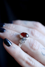 Anell de plata amb Granat i dues Calaveres.