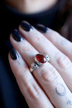 Anell de plata amb Granat i dues Calaveres.